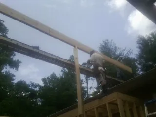 Carpenter setting a ridge beam over a new addition frame — Ice Dam Removal by Roofing Brothers in Mount Hope